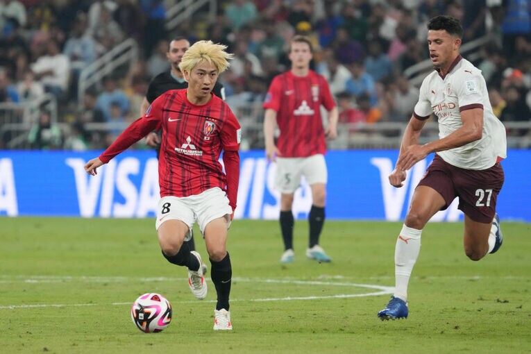 ヌネスをいなそうと懸命なプレーを見せる小泉　©Getty Images