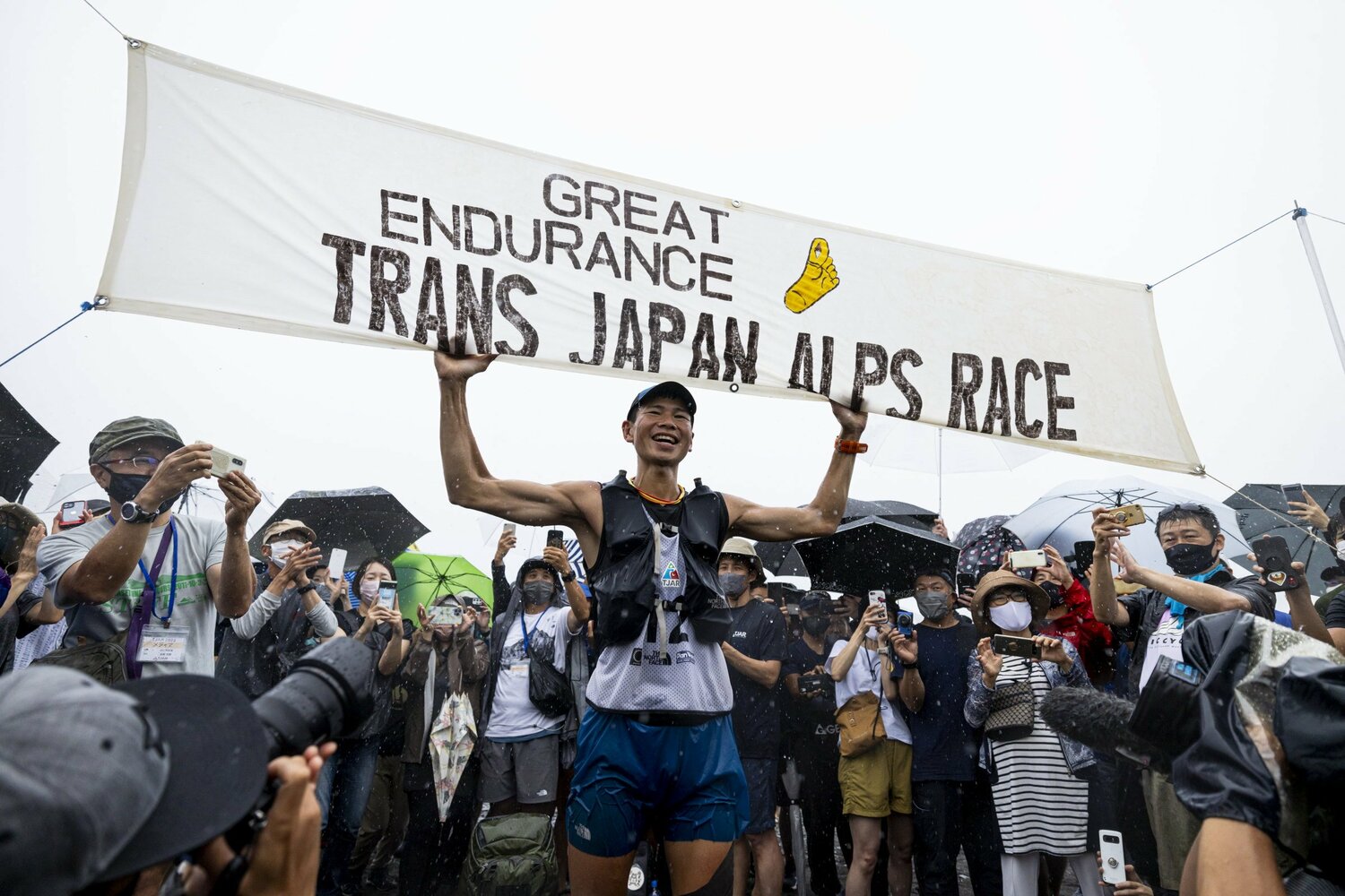 土砂降りの中、静岡の大浜海岸でゴールした土井陵。「4日17時間33分」という驚異的な大会新記録でTJAR初優勝　©Sho Fujimaki