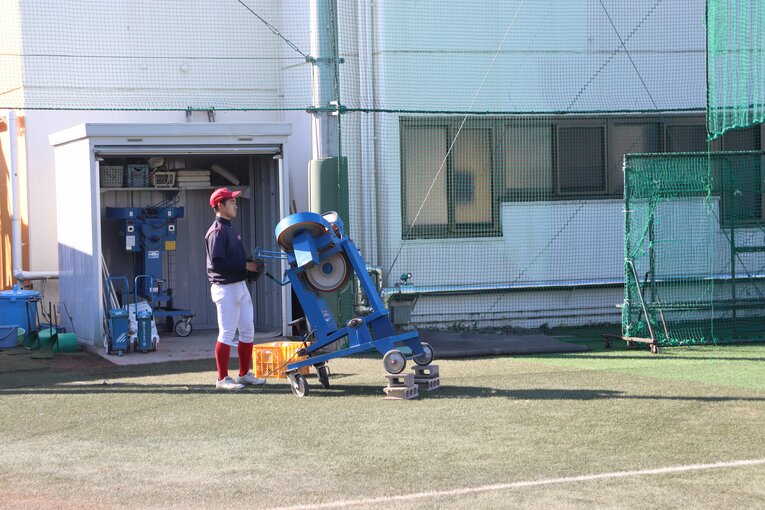 国学院久我山の練習風景。ノッカーが足りない時は、マシンを使って外野ノックを行っている　©Yuki Kashimoto