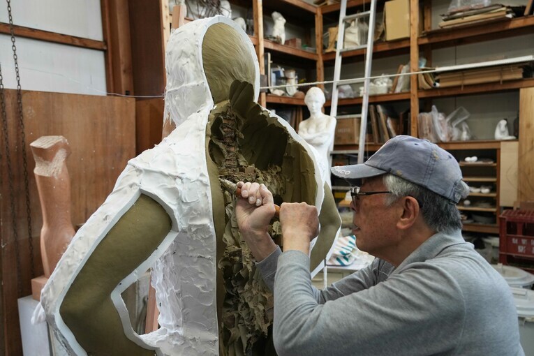 背中の部分の粘土を削り出す井野雅文さん