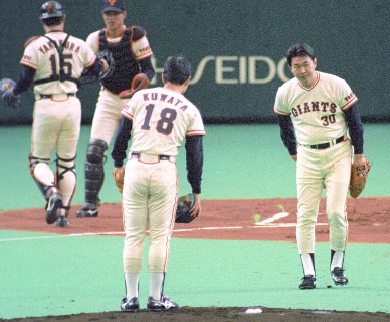 1988年3月18日のオープン戦「巨人対阪神」。「サヨナラ登板」をした江川卓が観客に頭を下げ、桑田真澄にマウンドを譲る　©KYODO
