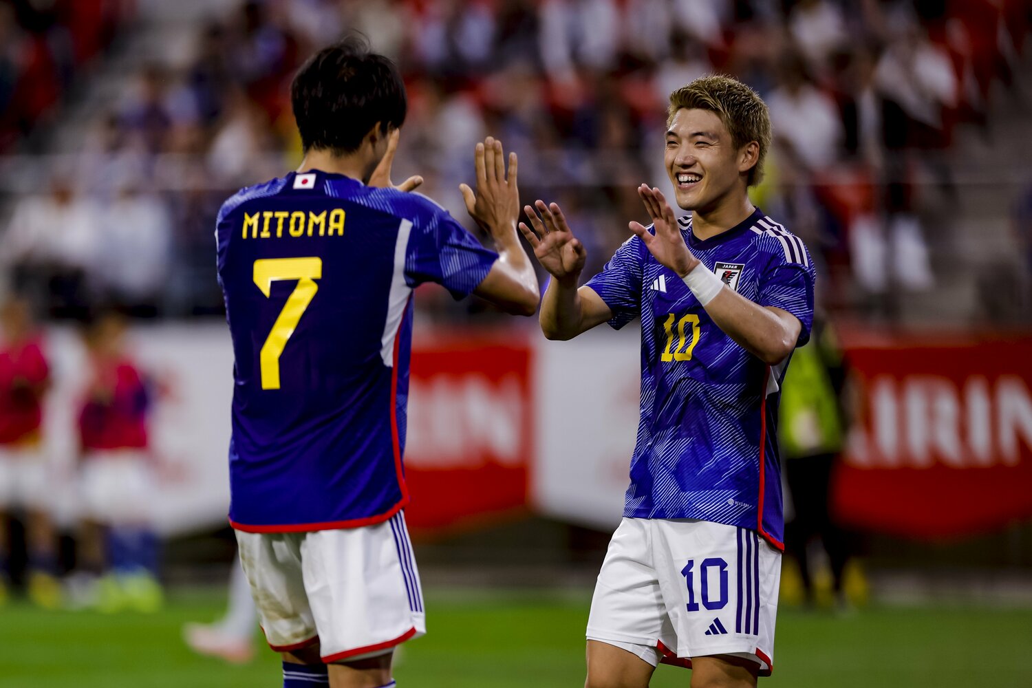 堂安とハイタッチする三笘　©Kiichi Matsumoto