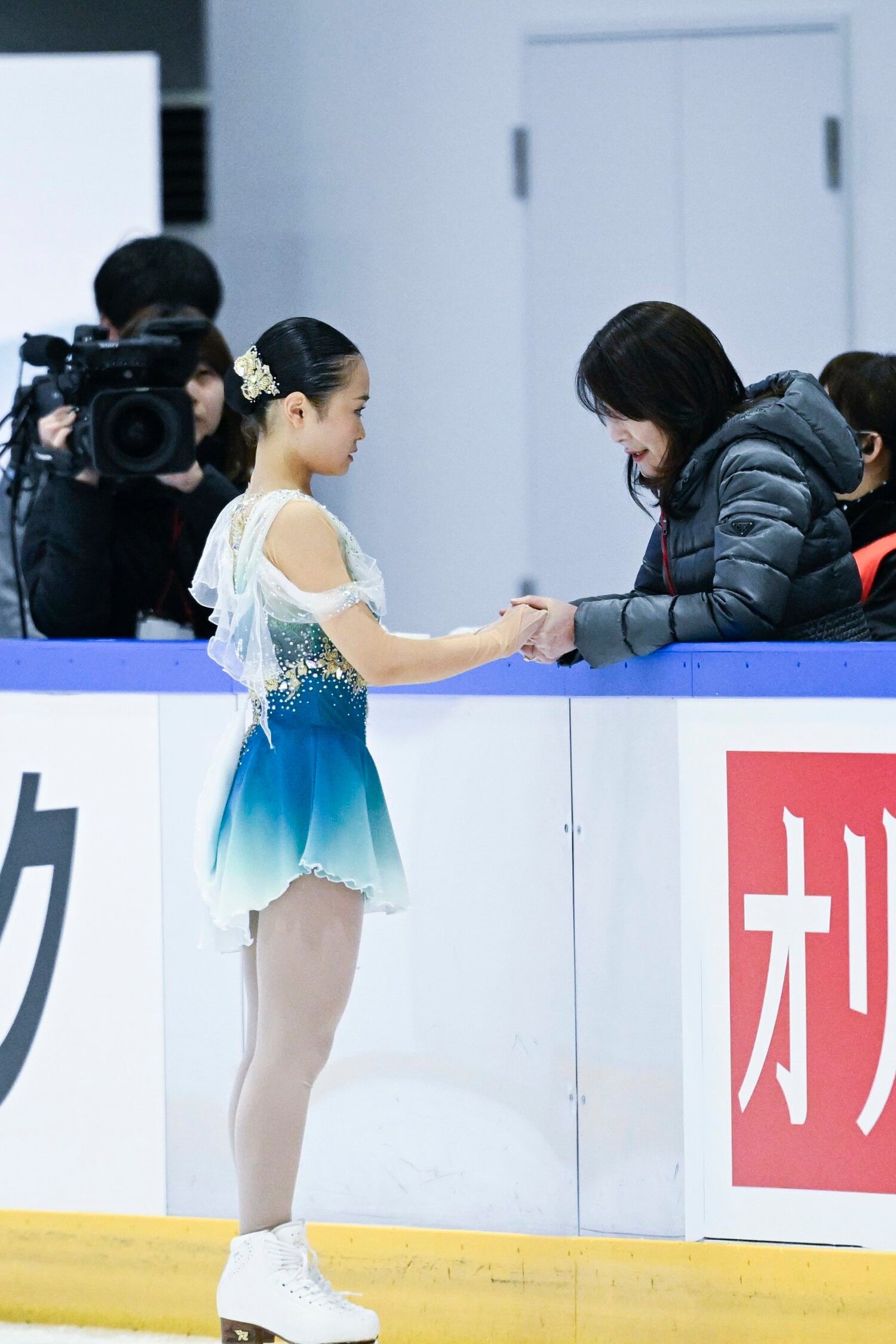 フリーの前に手を握る島田麻央と濱田美栄コーチ　©︎Asami Enomoto