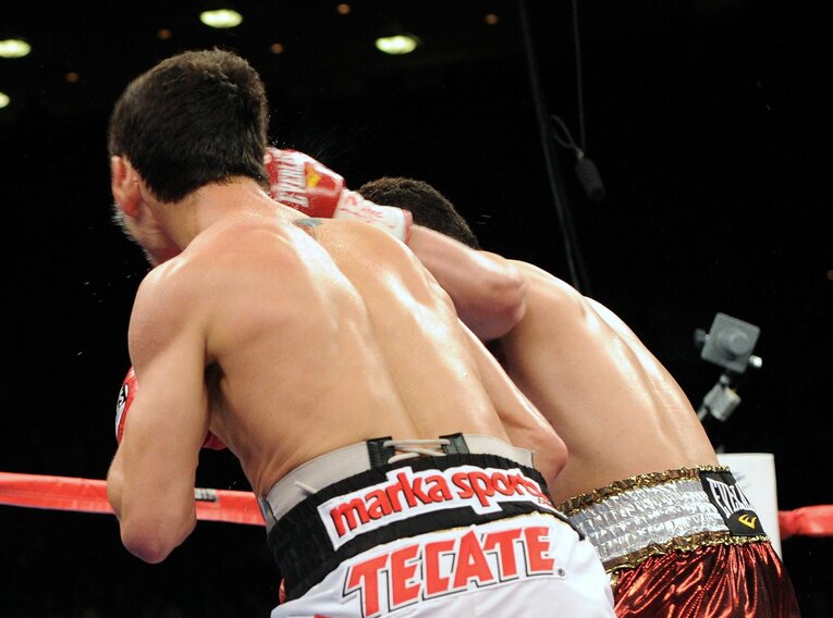 2011年2月19日、WBC・WBO世界バンタム級タイトルマッチ。挑戦者ドネアの左フックが王者モンティエルのテンプルに直撃した瞬間　©Naoki Fukuda