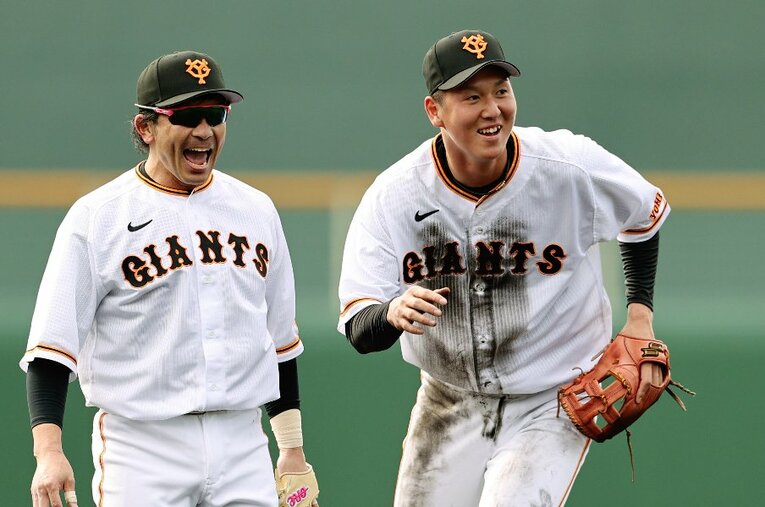 現在の巨人で55番をつける秋広優人（20歳）。写真は2月の宮崎キャンプで松田宣浩と ／ photograph by JIJI PRESS