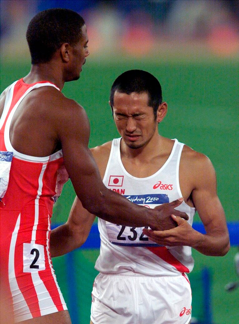 冒頭写真の続き。00年シドニー五輪、400mハードル予選で先頭を走りながら強風にあおられて転倒。レース後にその為末を慰めるパナマ代表の選手　©AFLO