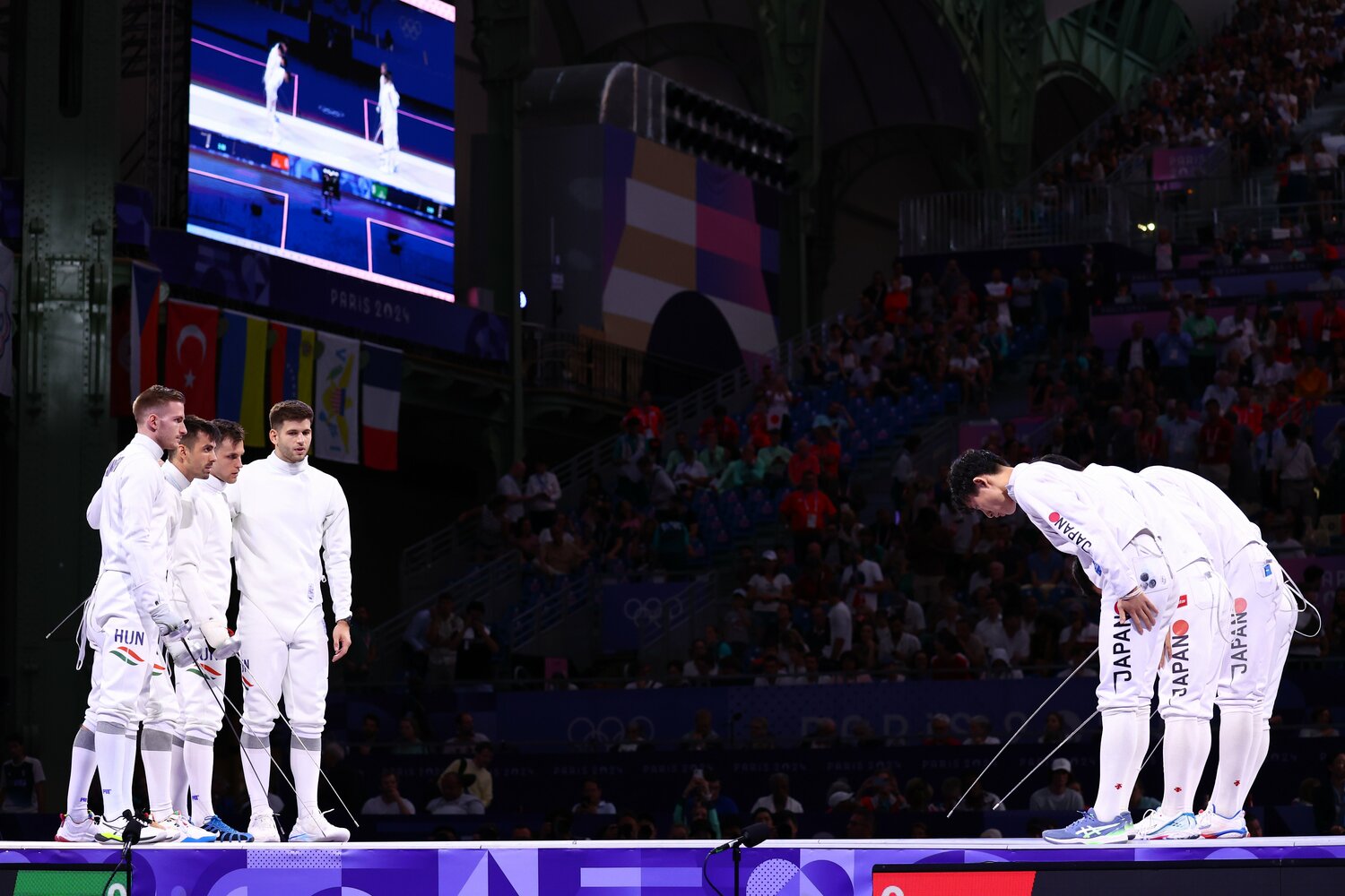 8月2日の男子エペ団体決勝戦。肩を組むハンガリーチームと一礼する日本チーム ©Ryosuke Menju/JMPA