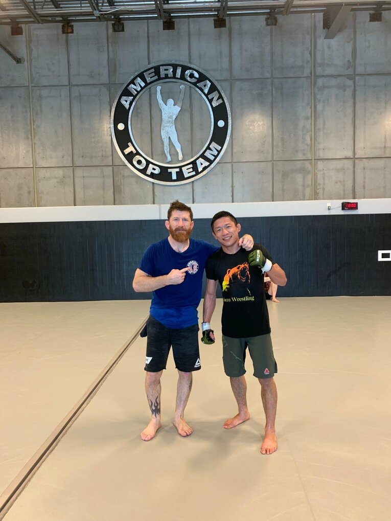 ATTのマイク・ブラウンコーチと笑顔で写真に収まる堀口　（本人提供）