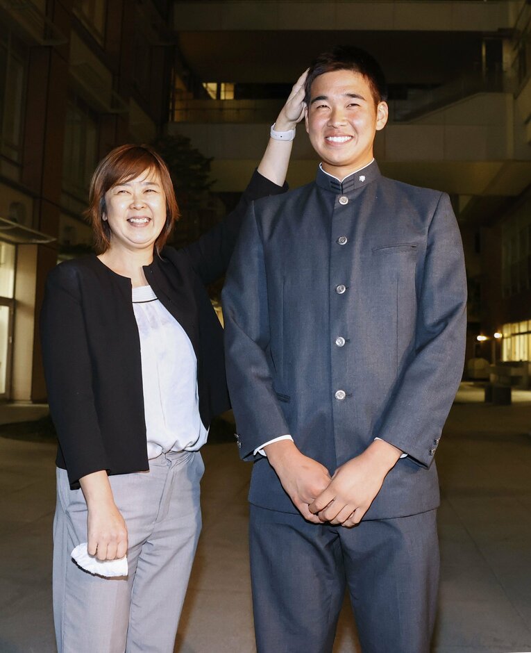 オリックスから1位指名を受け、母美智代さん（左）と笑顔を見せる山下