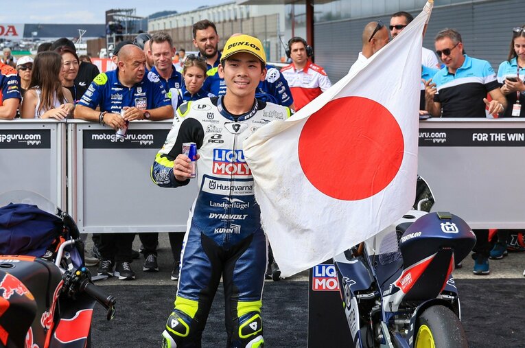 加藤大治郎の日章旗とともにコースを回り、パルクフェルメに戻った佐々木歩夢。旗の黄ばみが22年の歳月を感じさせる ／ photograph by Satoshi Endo