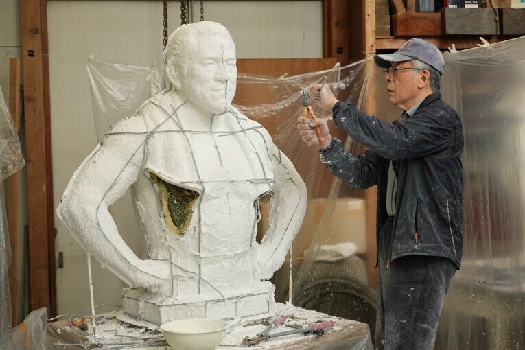 猪木像に針金を当てる作業を続ける井野雅文さん