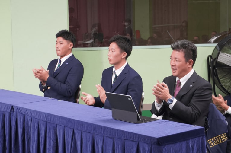 10月23日、仙台育英高校。ドラフト会議のテレビ中継を見つめる須江航監督。プロ野球志望届を提出していた3年生の高田庵冬（左）と吉川陽大（中央） ／ photograph by Kei Nakamura