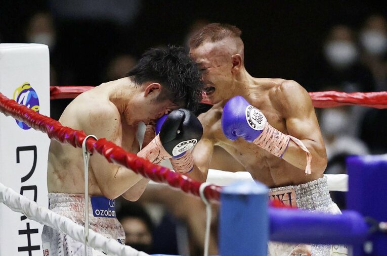 頭をつけ、死力を尽くしてパンチを打ち合う寺地拳四朗（左）と矢吹正道。必然的にバッティングが起きやすい距離だ ／ photograph by KYODO