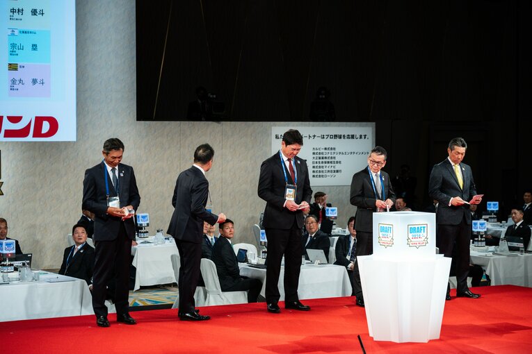 【2024ドラフト1位】5球団が1位指名した宗山塁（明治大）。楽天・森井誠之社長が当たりクジを引いた瞬間、苦い表情を見せた広島・新井監督（中央）と西武・西口監督　©Nanae Suzuki