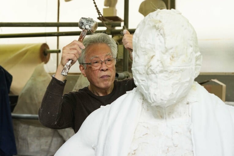 5月22日、石膏の猪木像の周りを槌で砕いていく井野雅文さん