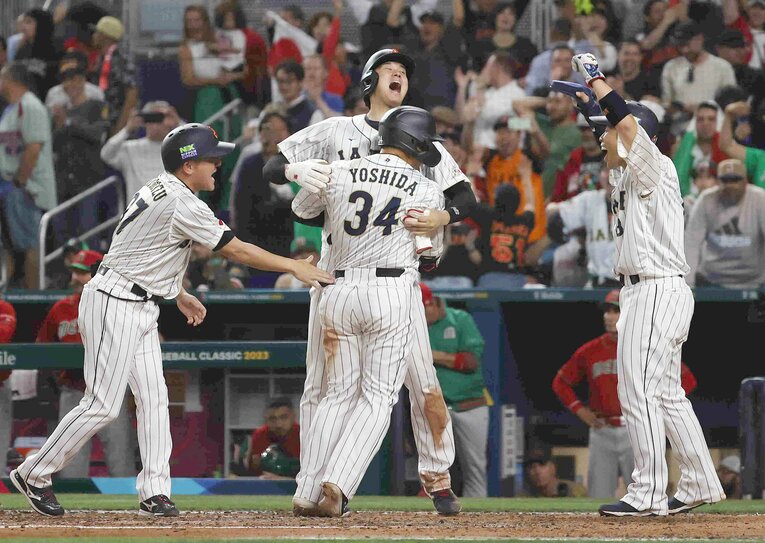 3ランホームランを放った吉田正尚を豪快に迎える大谷翔平　©JIJI PRESS