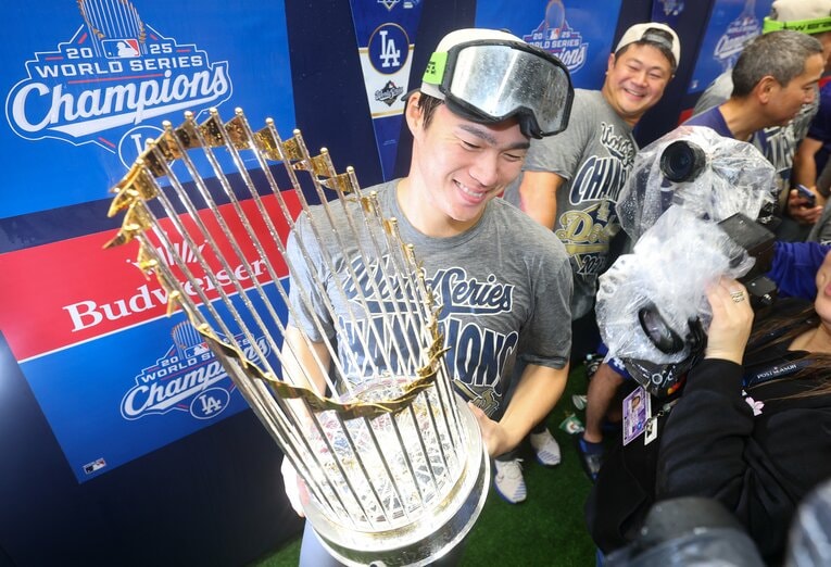 ワールドシリーズのトロフィーを手にする山本。園田通訳もニッコリ　©JIJI PRESS