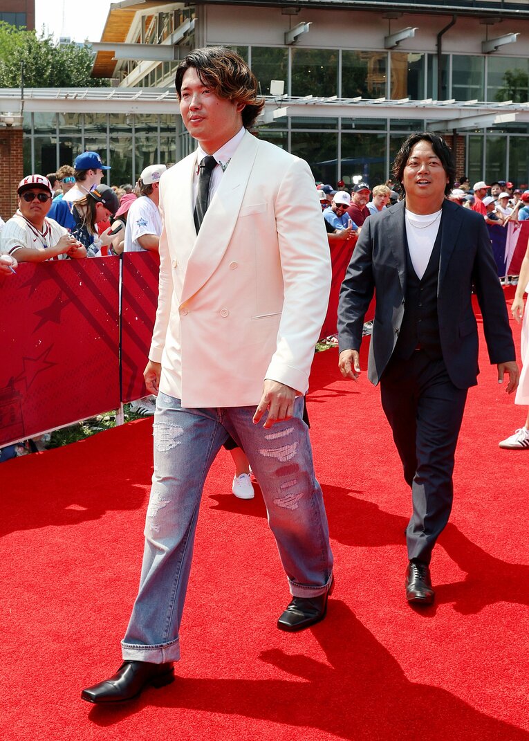 レッドカーペットショーを歩く村上宗隆と通訳の八木賢造さん　©︎JIJI PRESS