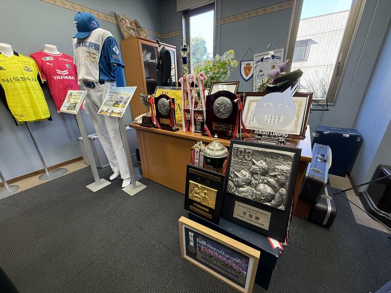 興國高校の応接室には卒業生のユニフォームなどが並ぶ ©Yuji Yanagawa