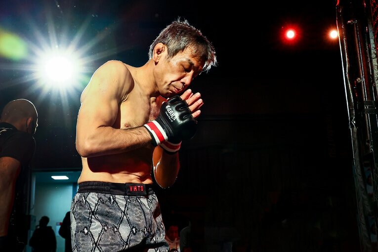 ケージに入る前に合掌する53歳の大石　©Susumu Nagao