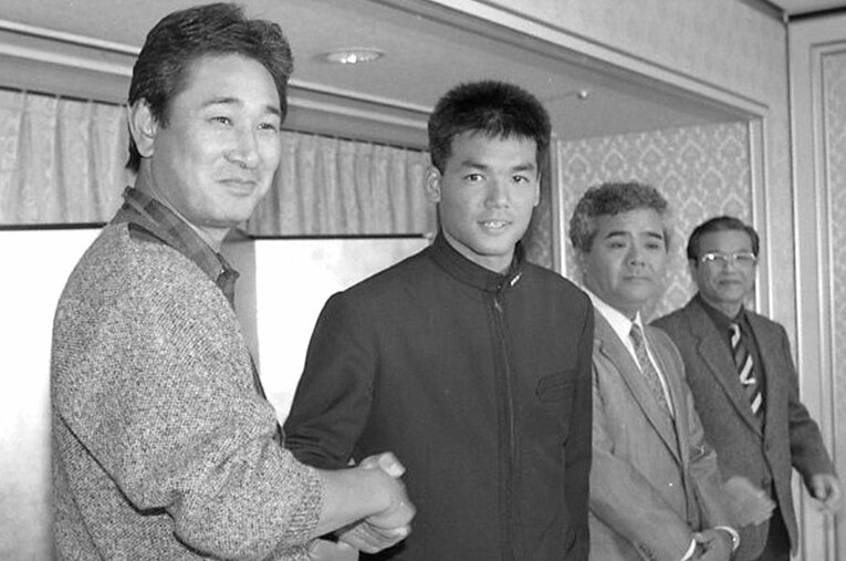 1987年12月、中日入団会見で握手をかわす星野仙一と沖縄水産高校の上原晃 ／ photograph by Okinawa Times/KYODO