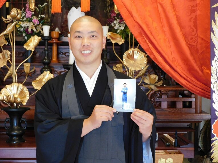 現役時代の写真を手に　©Jun Aida