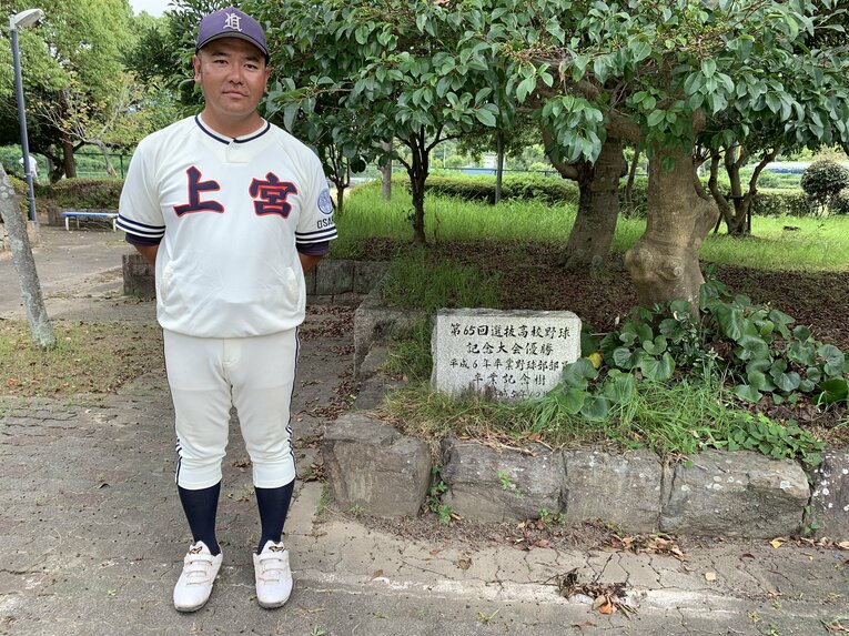 1993年センバツ優勝の記念樹と石碑の前に立つ村田監督　©Katsuharu Uchida