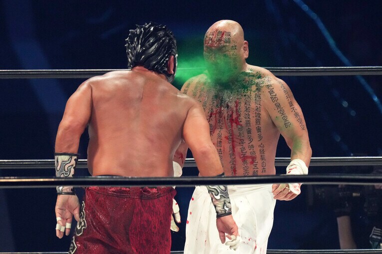 緑の毒霧を白使に吹き付けるムタ