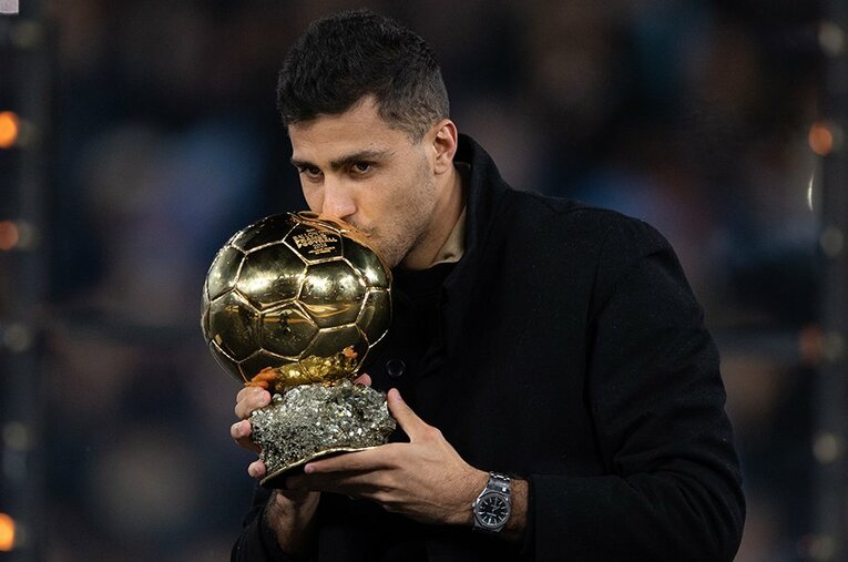 バロンドールのトロフィーにキスするロドリ。中盤深い位置の選手の受賞はサッカー史を変えたとも言える ／ photograph by Visionhaus/Getty Images