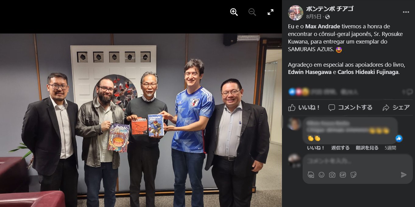 在サンパウロ日本総領事館の桑名良輔総領事に日本のフットボールに関する自著を進呈したチアゴ・ボンテンポ記者（サムライ・ブルーのユニフォーム姿）　※Facebookより