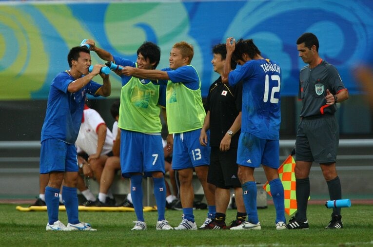 酷暑の北京で、岡崎に水をかける内田と安田　©JMPA