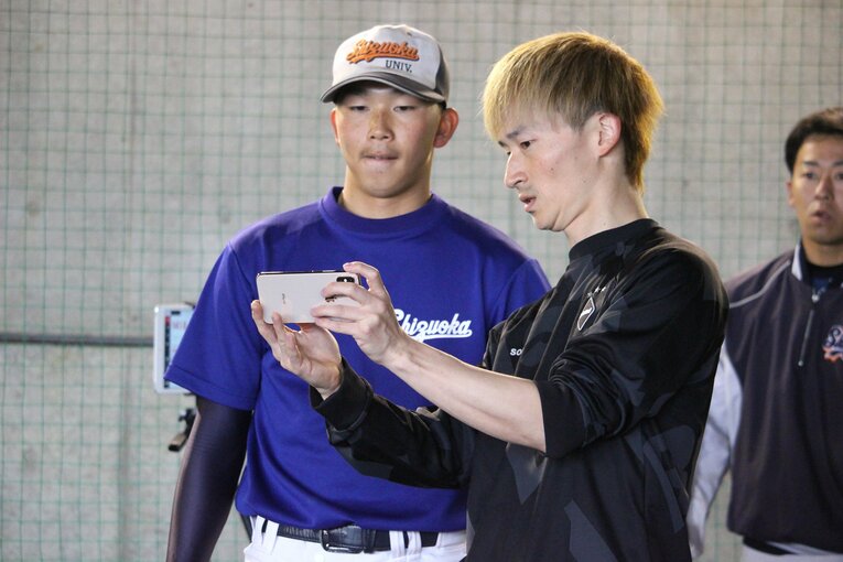 スマホを駆使しながら分析する北川雄介トレーナーの話を聞く石田　©Yu Takagi