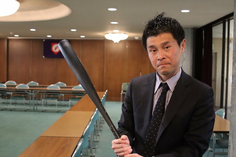 新規格の金属バットを持つ日本高野連の古谷事務局次長　©Kou Hiroo