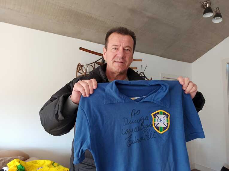 ペレのサイン入りの1958年のブラジル代表復刻ユニフォーム（「友人ドゥンガへ。エジソン・ペレより」と書いてある）を手に