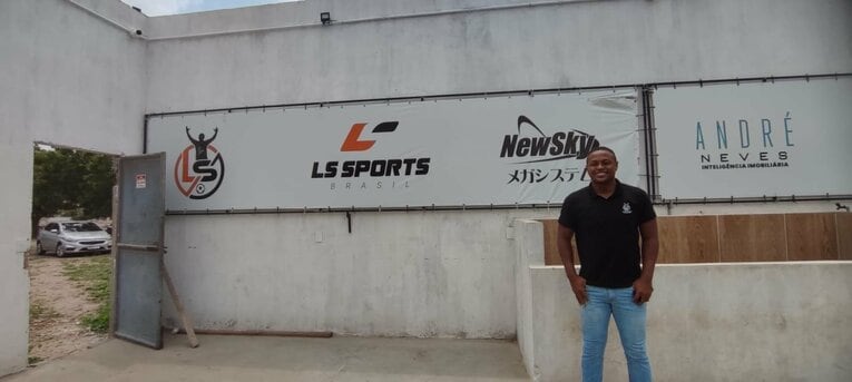 選手育成クラブのエンブレムの前で。「LS」はレオ・シルバの頭文字。©Hiroaki Sawada