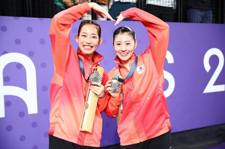 銅メダルを獲得し、2人でハートのマークを作るシダマツペア。志田千陽（右）と1歳年下の松山奈未（左）は「なみ」「ちぃ」と呼び合う仲だ ／ photograph by Ryosuke Menju/JMPA