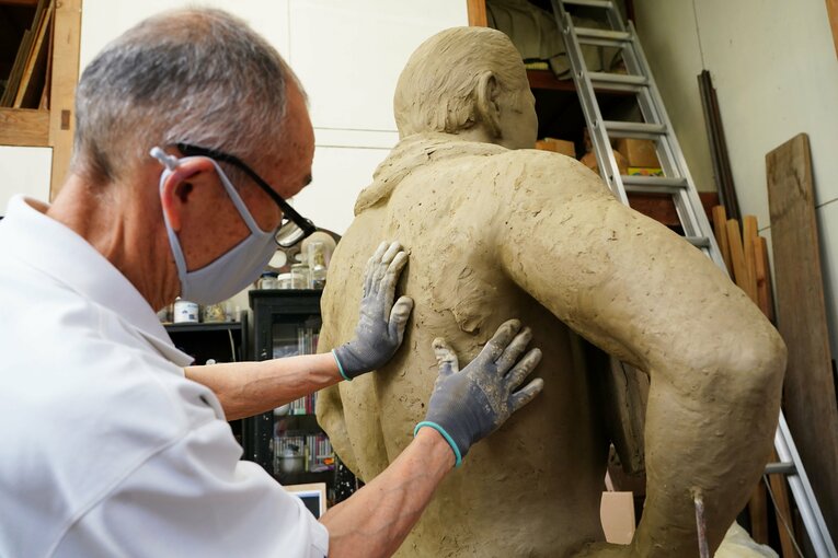 4月14日、猪木像の背中に粘土を塗る彫刻家・北井博文さん