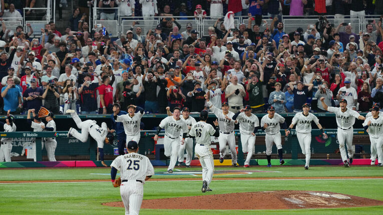 大谷翔平がマイク・トラウトを打ち取った瞬間、ベンチを飛び出す侍ジャパンの選手たち。（後方左の）吉田正尚は慌てたのか、まさかの転倒…すぐに立ち上がって笑顔で歓喜の輪に加わった　©︎NIKKAN SPORTS/AFLO