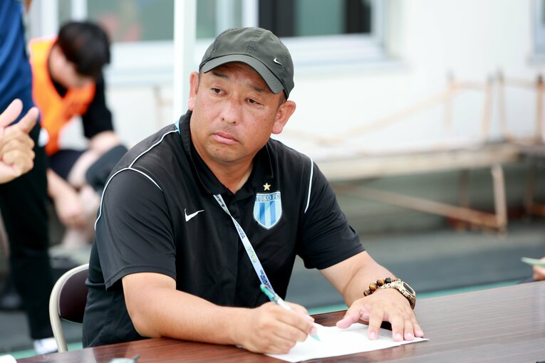 現役時代はアビスパ福岡やサガン鳥栖でプレーした鈴木勝大監督。2012年より母校のコーチに就任、2013年より名将・佐熊裕和氏の後を継いで監督に就任した。現在、日本代表でコーチを務める中村俊輔の1学年先輩にあたる　©︎JFA/AFLO