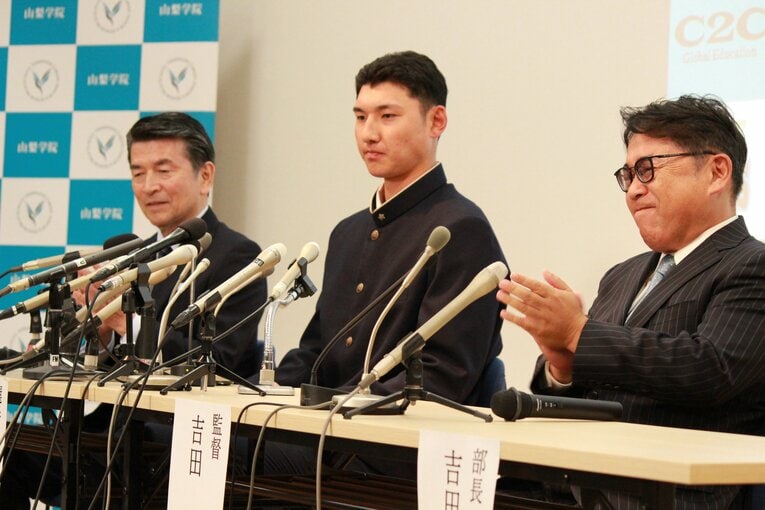 日本ハムから指名を受け、表情を変えないように努める菰田（中央）　©Yusuke Kondo