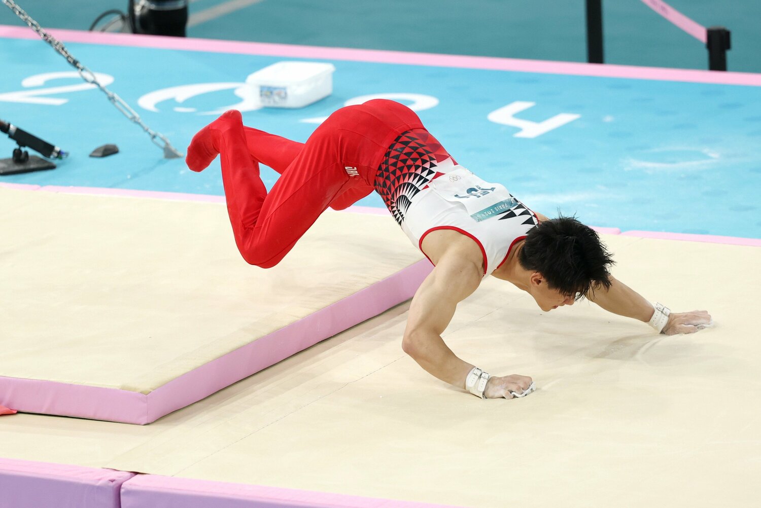鉄棒の着地で大きく前方に両手をついた橋本 ©JIJI PRESS