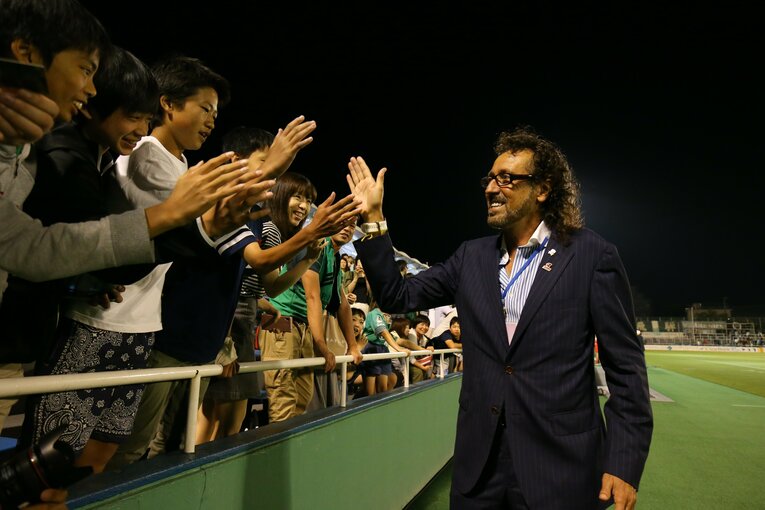 子どもたちと笑顔でハイタッチするラモス瑠偉　©︎J.LEAGUE