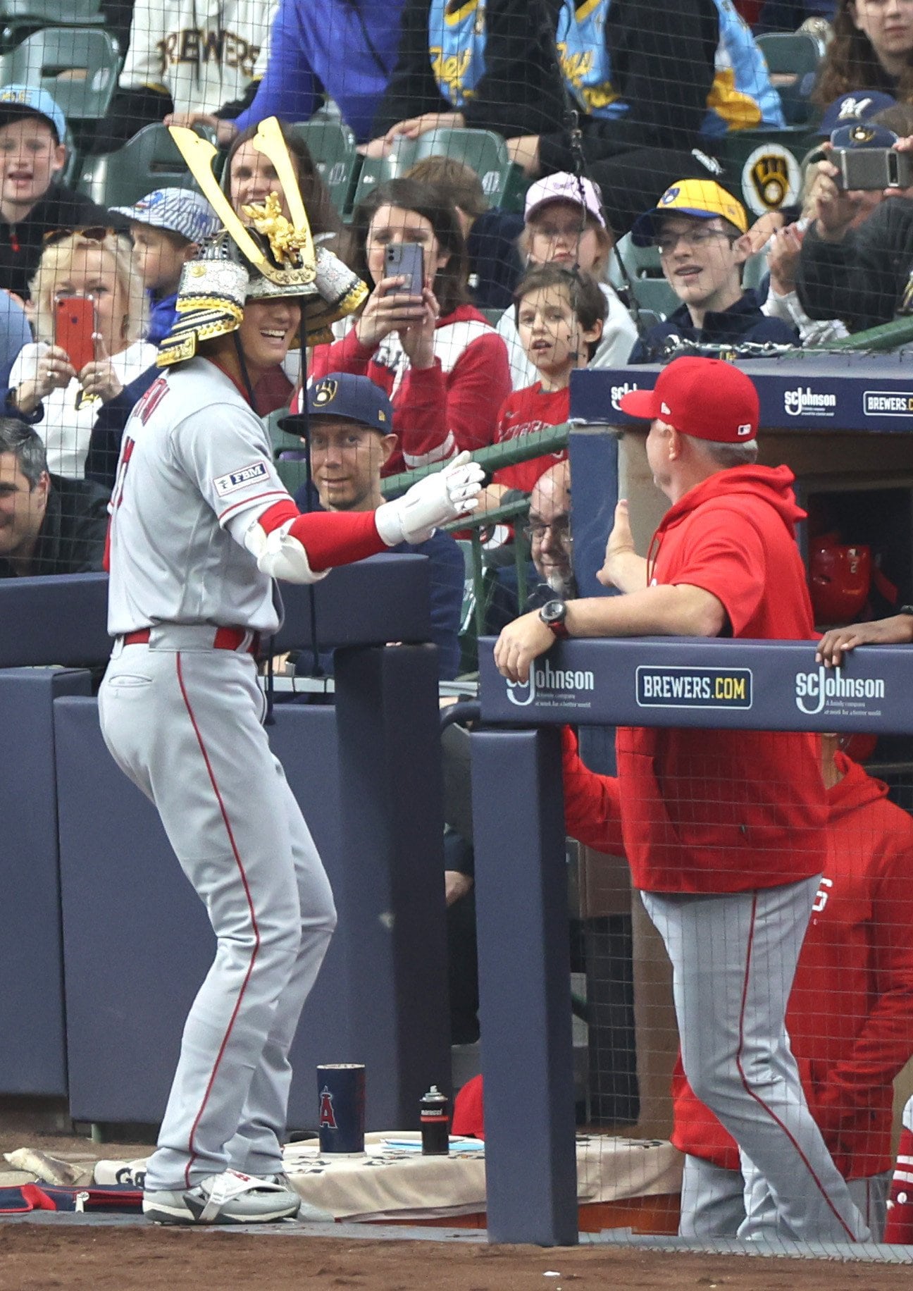 ホームランを放ち、兜をかぶってネビン監督に迎えられる大谷翔平　©JIJI PRESS