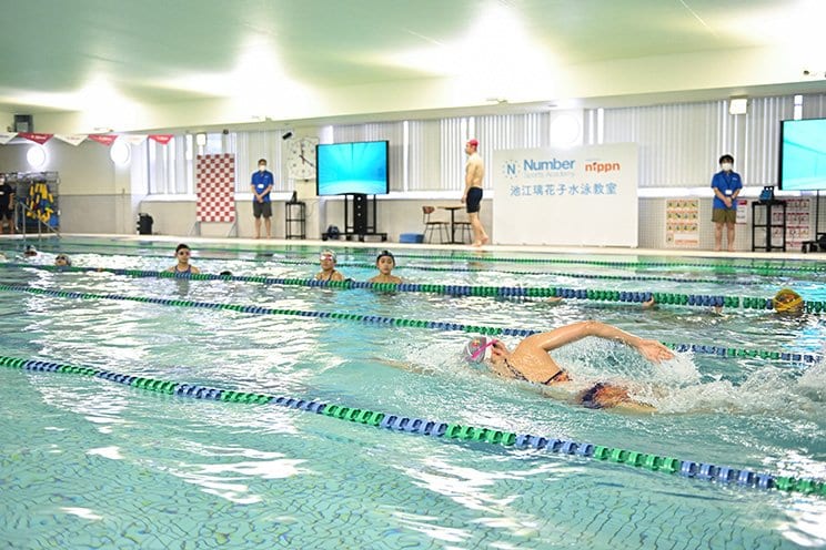 憧れの選手が見せるクロールの模範泳法を“特等席”の水中から見学する参加者たち