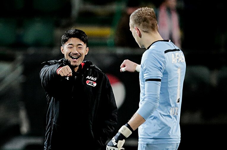 AZのチームメートと明るい表情で触れ合う菅原由勢。そのキャラクターを前面に、欧州の舞台で走り回ってほしい。 ／ photograph by Getty Images