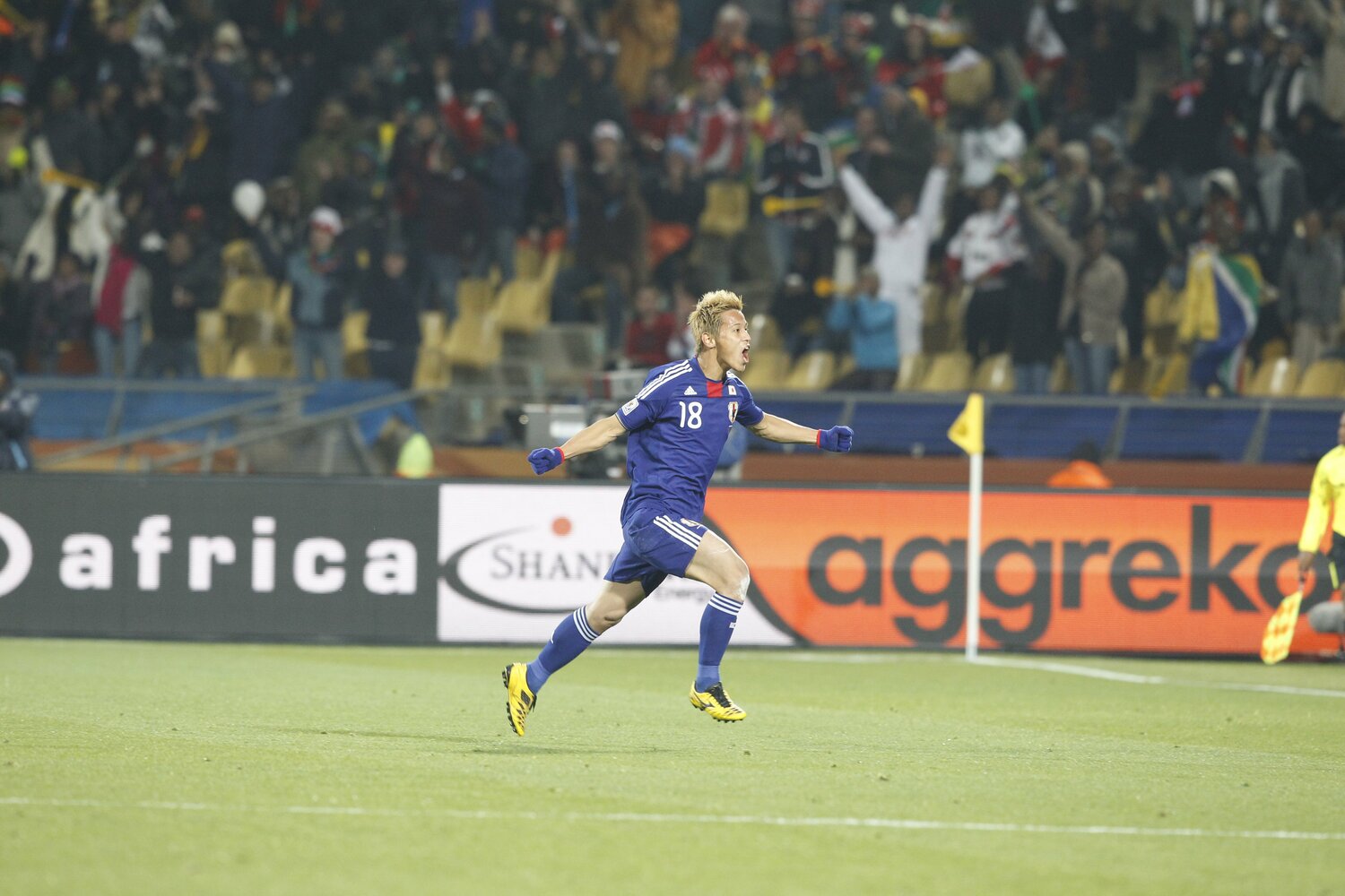 南アフリカW杯のデンマーク戦で約30mの直接フリーキックを決め、雄叫びをあげながら駆ける本田　©︎JMPA