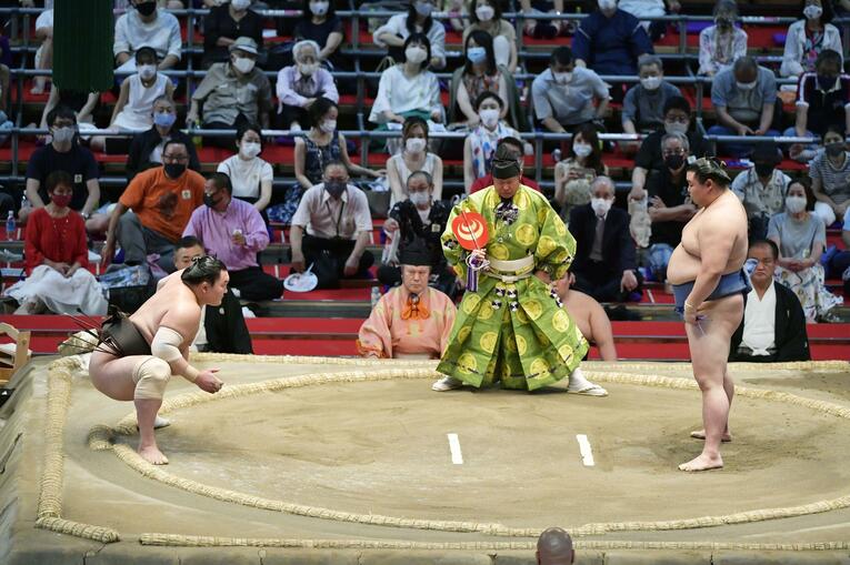 名古屋場所14日目。俵付近にまで極端に下がって遠い距離で正代（右）と向き合う白鵬。浴びせ倒しで下す　©KYODO