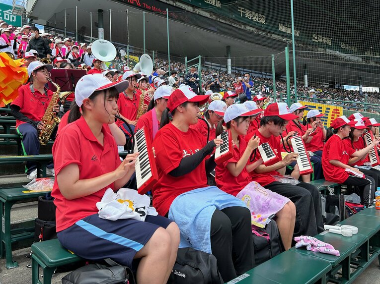 なるべく日差しのもとで吹きたくない木管楽器担当の生徒は、代わりに鍵盤ハーモニカを演奏する学校も（土浦日大）　©Yukiko Umetsu