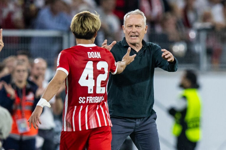 堂安を迎え入れるシュトライヒ監督　©Getty Images