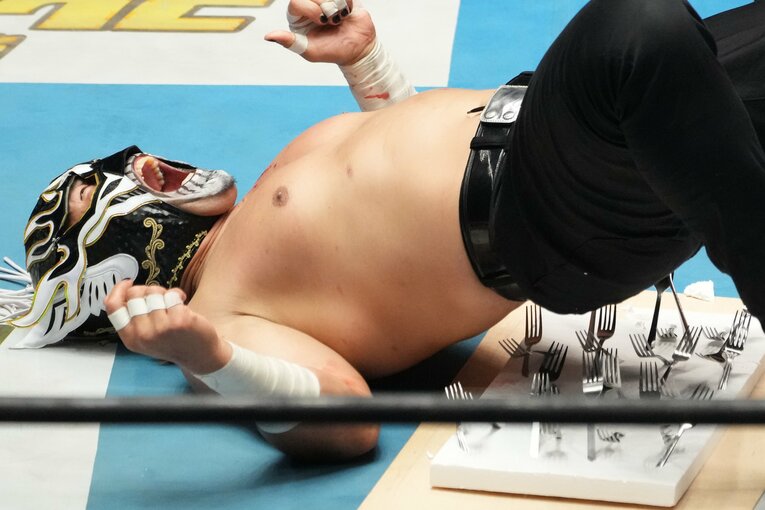 フォークが背中に突き刺さり、痛みに悶絶するエル・デスペラード